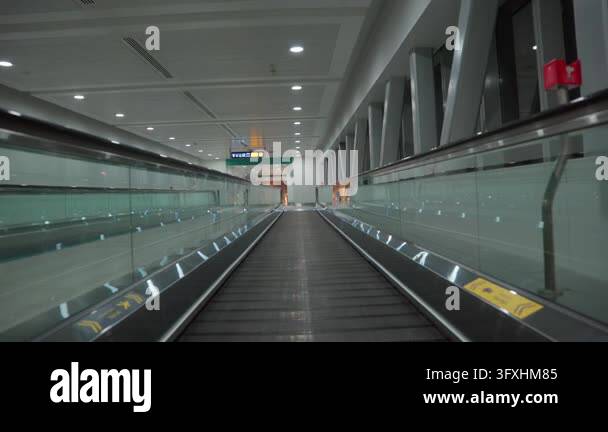 An Overhead Direction Sign Moving walkway carries the viewer through an empty airport terminal ...