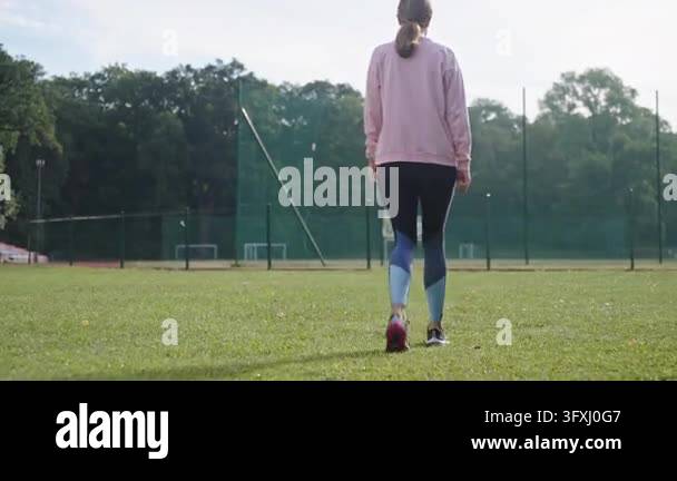 Woman walking to stadium for morning workout back view of female ...