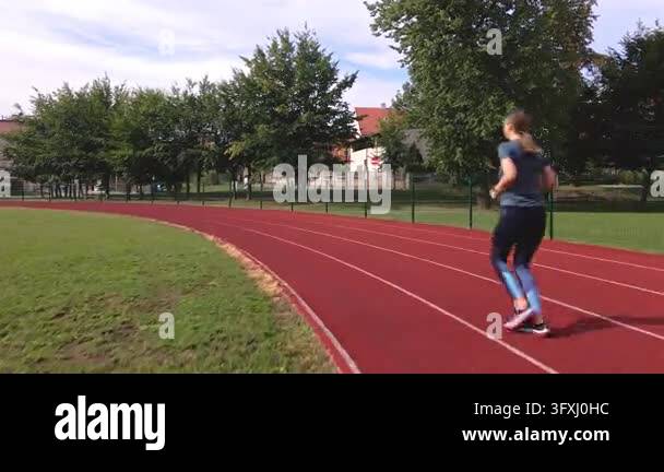 Run Outside Track Woman running on a track during outdoor exercise Female runner training ...