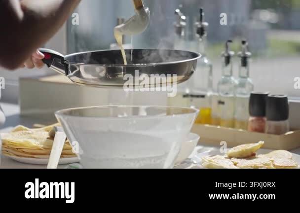 Person pouring pancake batter into a hot frying pan with a ladle Pan ...