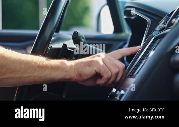 Hand pressing the start button on dashboard inside a car Close view of ...