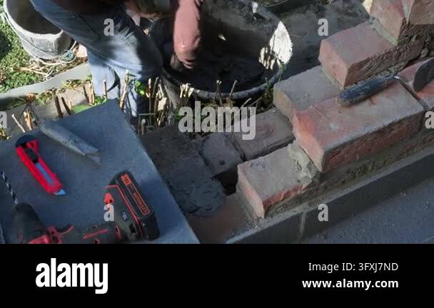 Fresh mortar is spread with a bricklayers trowel during the repair and ...