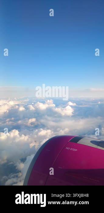 View from airplane window of jet engine flying high above white fluffy ...