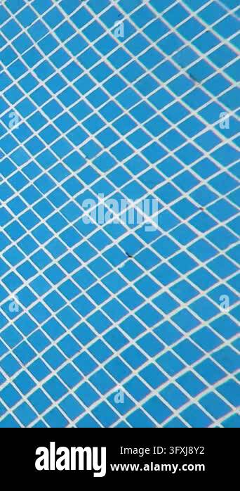 Submerged tracking shot moving slowly across a swimming pool floor ...