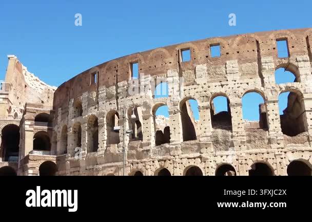 Majestic view of the ancient Colosseum facade against a bright blue sky ...