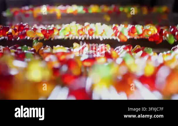 Colorful gummy bears moving along an automated production line at a ...