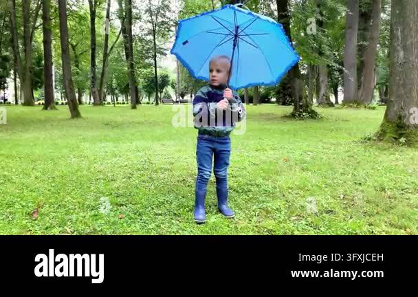 Little Activity Little boy child in raincoat,rubber boots playing with umbrella in ...