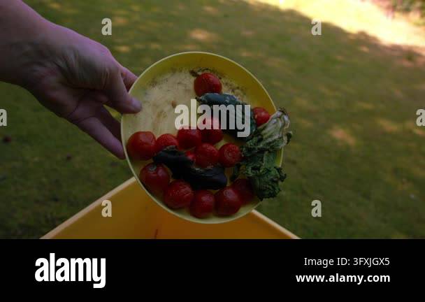 Throwing food scraps waste into compost bin medium 4k slow motion shot ...