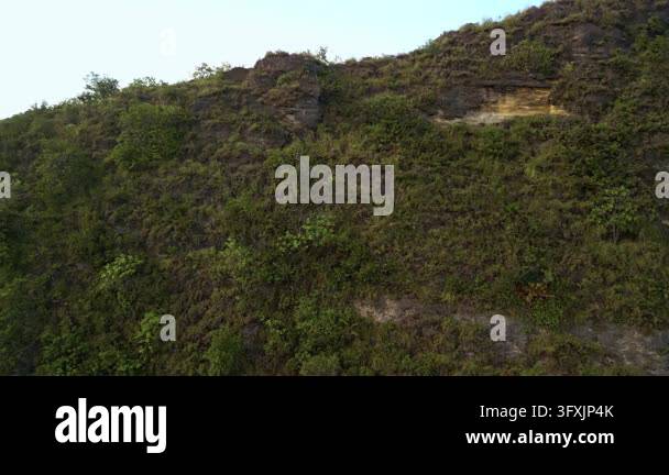 A sweeping aerial tracking shot reveals the dramatic cliffs and ...