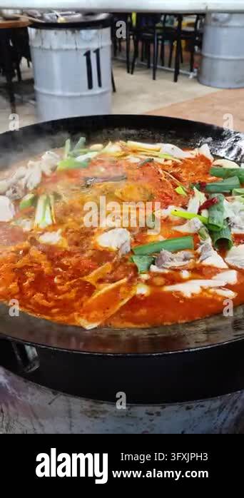 Close up of spicy korean braised chicken stew boiling in a large ...