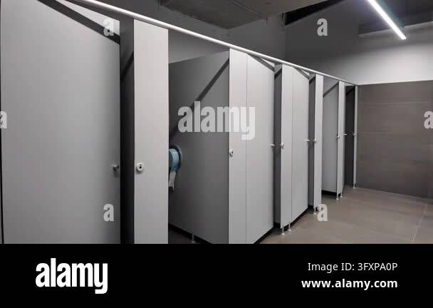 Row of modern toilet cubicles inside a clean public restroom with ...