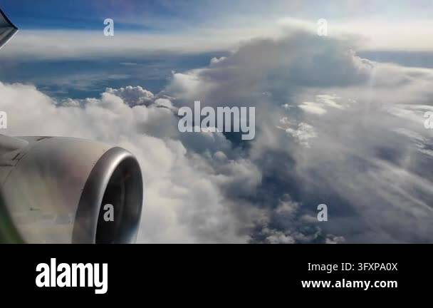 Bright blue sky and white clouds seen from a passenger airplane window ...