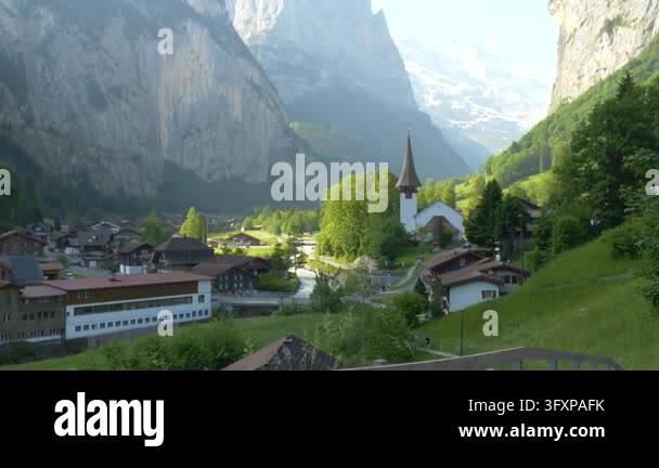 Beautiful church and rural houses surrounded by green vegetation and ...