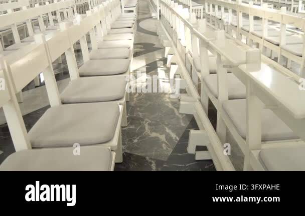 White wooden church pews with comfortable cushions arranged neatly for ...