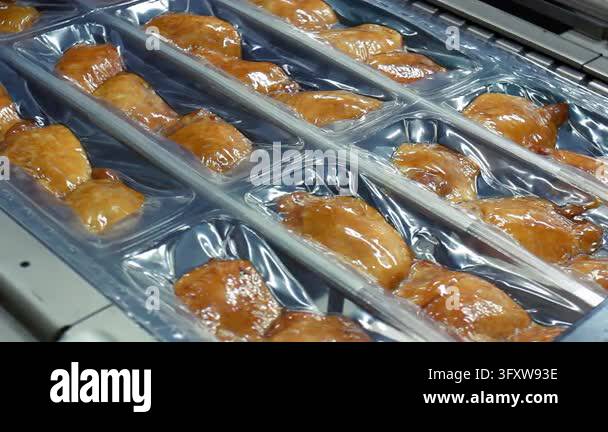 Packaged smoked chicken thighs moving conveyor belt meat factory ...