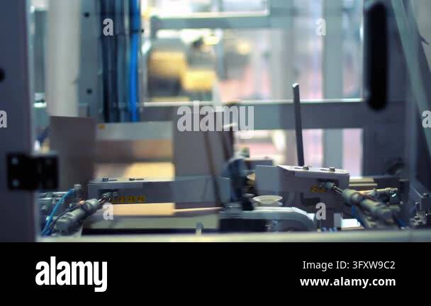 Carton erecting machine folding cardboard blank into box closeup ...