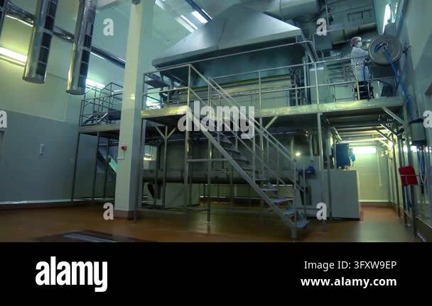 Food production plant workers lab coats walking toward stairs, operator ...
