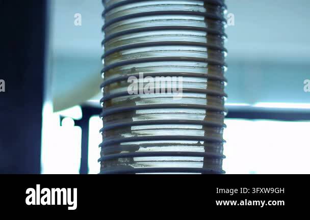 Closeup plastic lids stack inside spiral feeder tube dairy plant ...