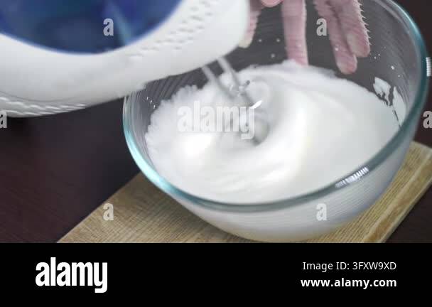 Whipping egg whites hand mixer glass bowl, fluffy white meringue foam ...