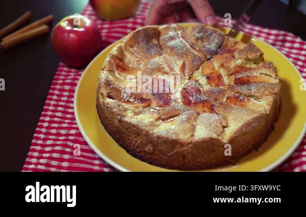 Apple dessert served yellow plate, hand cutting pie slices knife ...