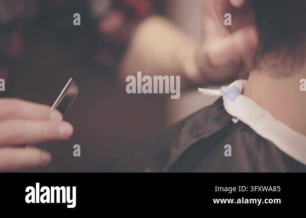 Straight razor haircut closeup, barber hands holding comb, cutting hair ...