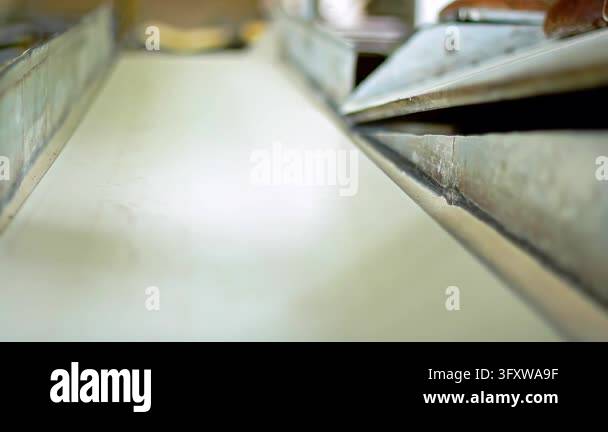 Bread production line old factory, round brown loaves sliding down ...