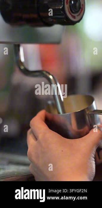 Cinematic close up of barista hands steaming and frothing milk in ...
