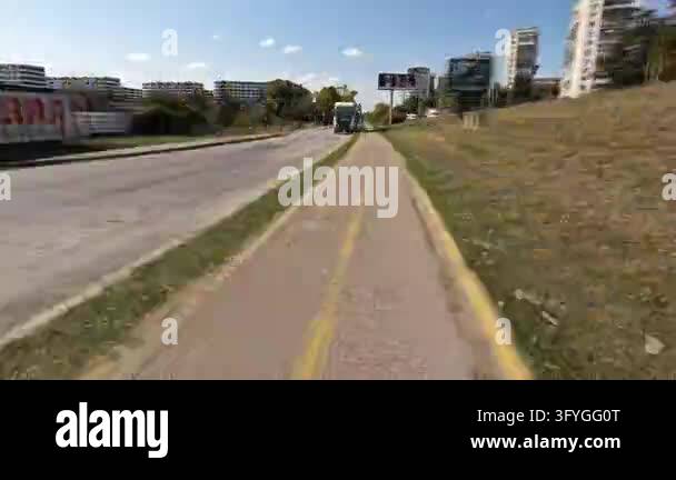 First person perspective of riding a bicycle on a dedicated bike lane ...