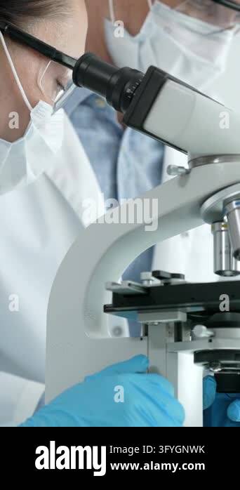 Female research scientist carefully analyzing samples under a ...