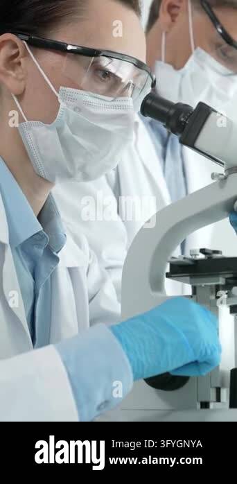 Female research scientist carefully analyzing samples under a ...