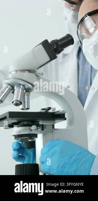 Female research scientist carefully analyzing samples under a ...