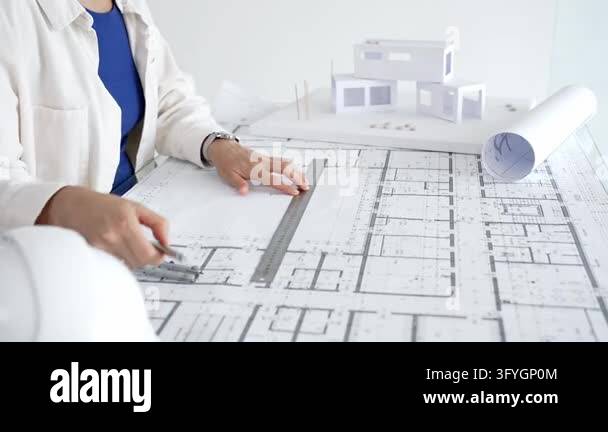 Architect hands using a compass and ruler on a detailed blueprint ...