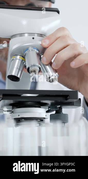Operando Optical Microscopy Scientist looking into an optical microscope while working on an ...