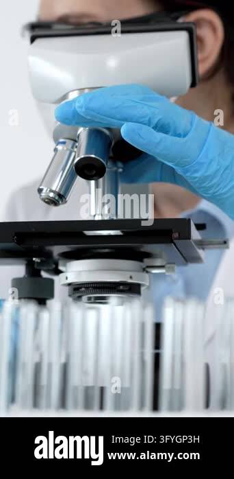Scientists in a laboratory performing medical research, looking through ...