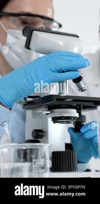 Scientists in a laboratory performing medical research, looking through ...