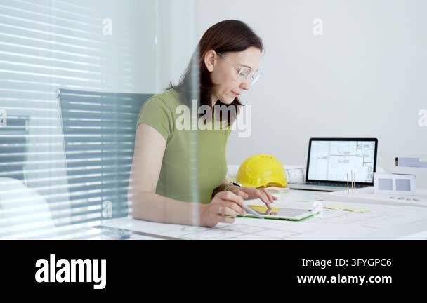 Woman architect actively drafting architectural plans and engineering ...