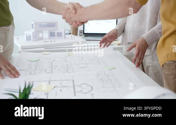 Architecture team hands pointing at building blueprints and house model ...