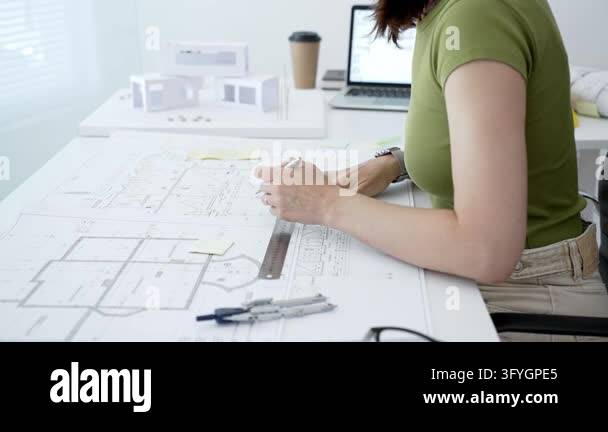 Woman architect actively drafting architectural plans and engineering ...