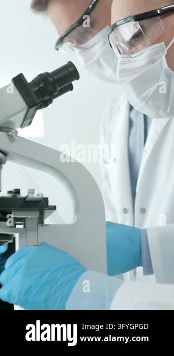 Female research scientist carefully analyzing samples under a ...