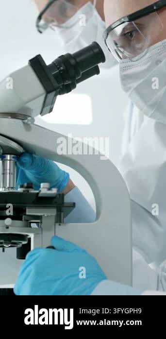 Female research scientist carefully analyzing samples under a ...