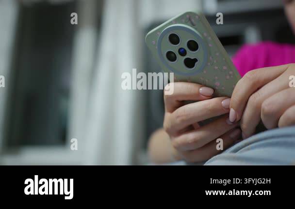 Woman holds and operates a modern smartphone protected by a patterned ...