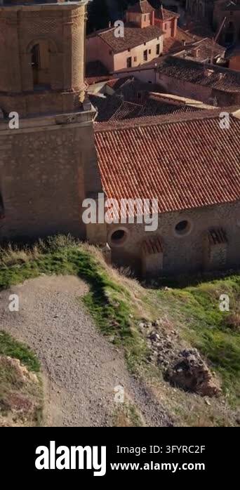 Drone camera soaring past church bell tower, revealing ancient hillside ...