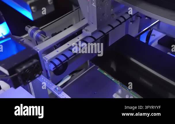 Automated machine with cable chain over laptop display panel. Blue ...