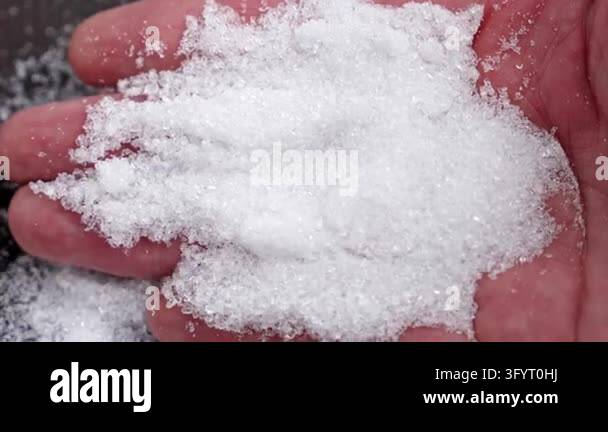 Mound of white Epsom salt crystals (magnesium sulfate) held in an open ...