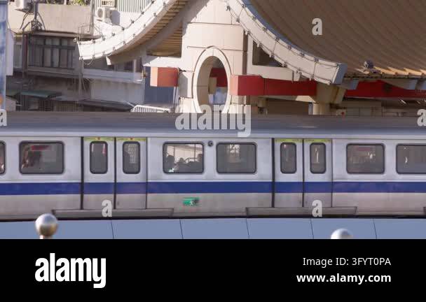 Slow motion follows a silver Taipei metro train passing below a ...