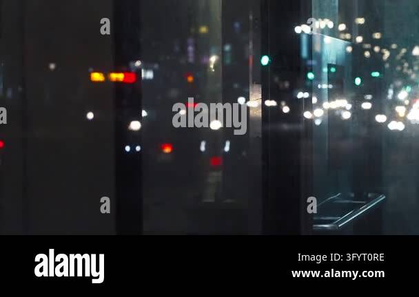 Slow motion captures distant headlights and colorful traffic lights ...