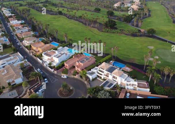 Aerial drone view of luxury villas with swimming pools beside the green ...