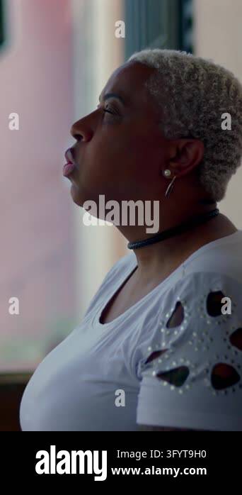 Profile portrait of an African American woman taking a deep breath in ...