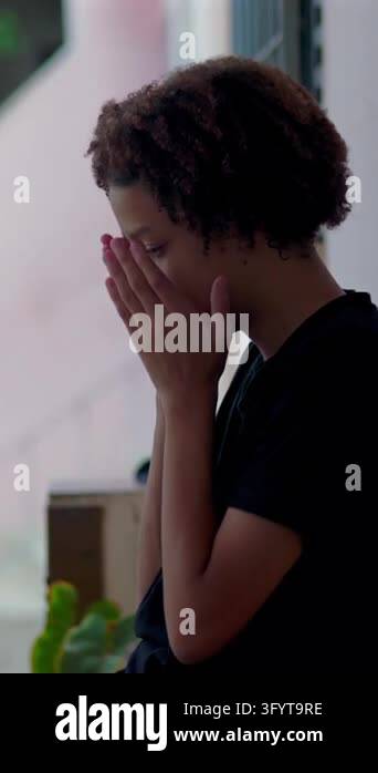 Medium close-up of a heartbroken Hispanic boy of African descent hiding ...