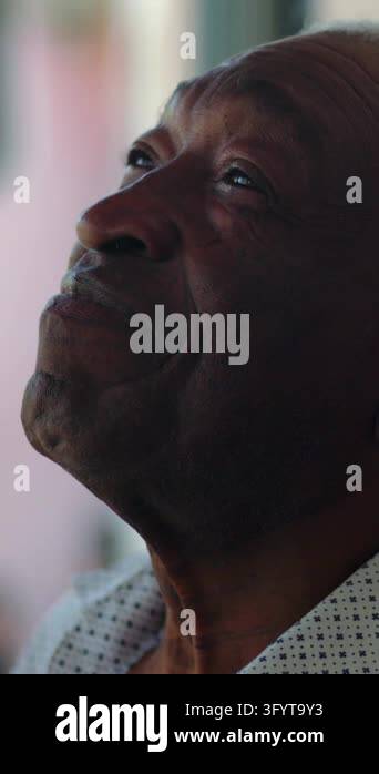 Low-angle portrait of a pensive African American senior man looking up ...